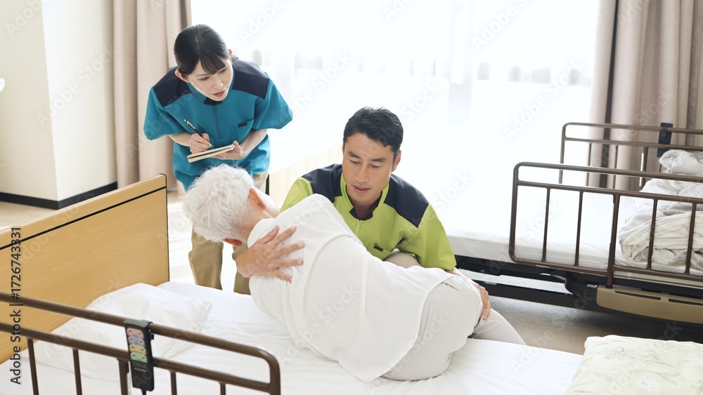 Obraz premium 体位変換の指導を行うアジア人介護士