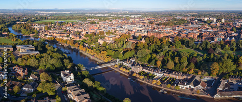 Photos Panoramic sunrise view of Chester with the River Dee, Grosvenor Park, and Queen’s Park Suspension Bridge surrounded by autumn trees