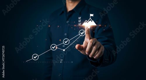 Man pointing at a digital growth chart leading to a mountain peak with a flag, symbolizing business goals, achievement, and success through strategic planning and progress