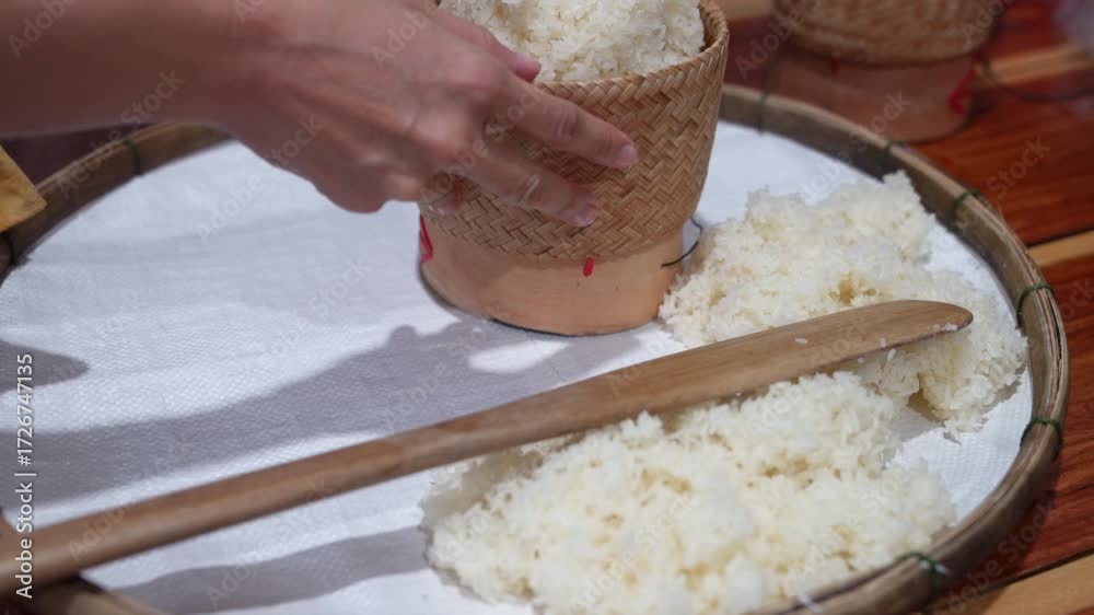 The chef uses a small, long stick to stir the rice until it cools down ...