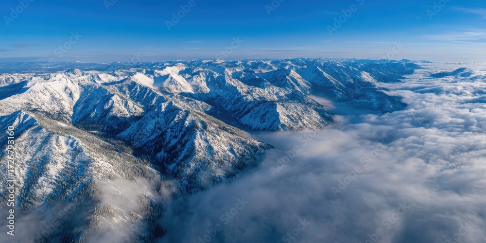 Obraz premium A wide angle landscape of a snowy mountain range towering above a serene valley