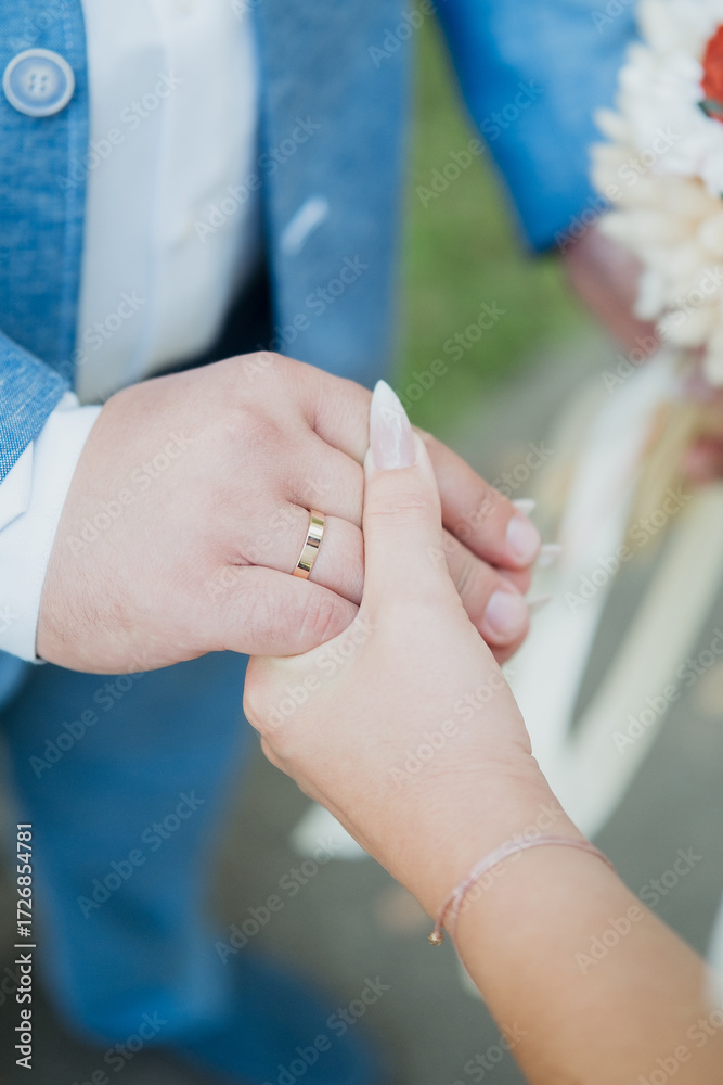 Fototapeta premium Bride and groom holding hands with wedding rings for romantic unity concept