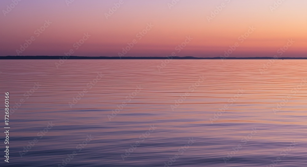 Fototapeta premium Serene lake water reflects vibrant sunset hues creating a peaceful natural backdrop