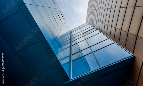 bottom view of the windows and walls of a tall business building in a modern city