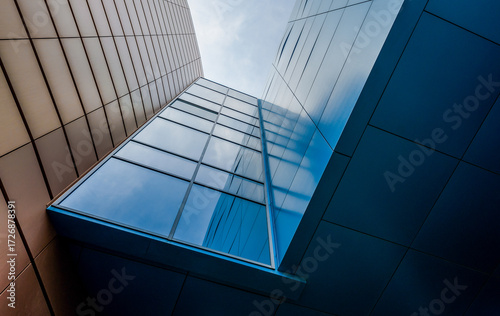 bottom view of the windows and walls of a tall business building in a modern city