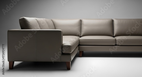 Minimalist Leather Sectional Sofa in Taupe with Wood Legs Against Grey Backdrop