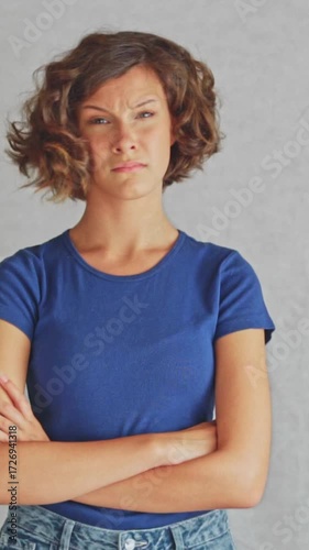 Skeptical female with raised eyebrow and crossed arms expressing strong doubt  expressing strong doubt and disbelief in mobile format, white background