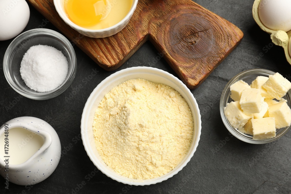 Fototapeta premium Cornbread preparation. Different ingredients on black textured table, flat lay