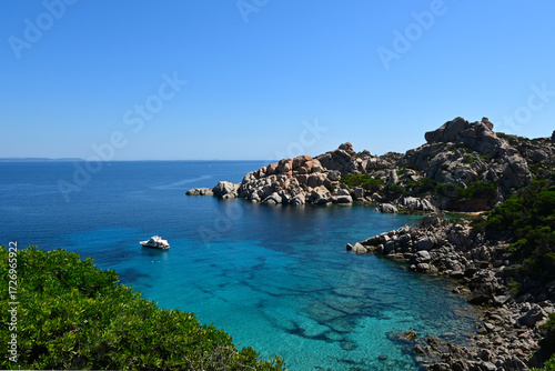 Rocky coastline of Capo Testa in Sardinia, with turquoise waters, granite cliffs, green vegetation and cloudless sunny sky