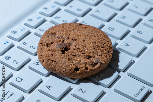 Close-up of a cookie on a computer keyboard. Internet cookies, technology, and online privacy concepts.