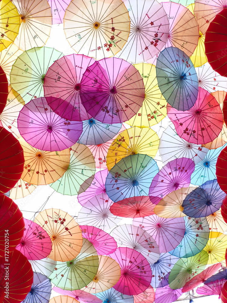 Naklejka premium Colorful Chinese umbrellas hanging together creating a beautiful, vibrant overhead display.