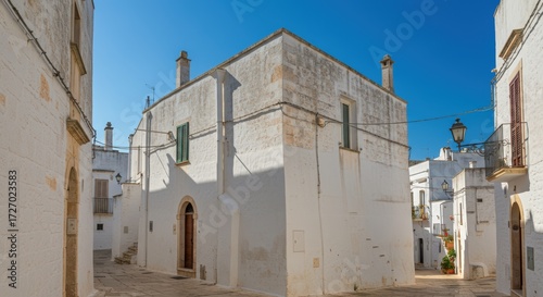 Whitewashed buildings in narrow alleyway sunny day