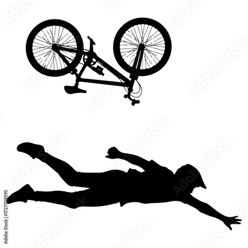 Silhouette of a cyclist falling off a mountain bike.