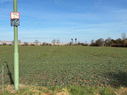 Field and streetlight pole with a RWE lignite excavator in the background and the village of Bürgewald (formerly Morschenich), Germany, Europe, on February 25, 2025