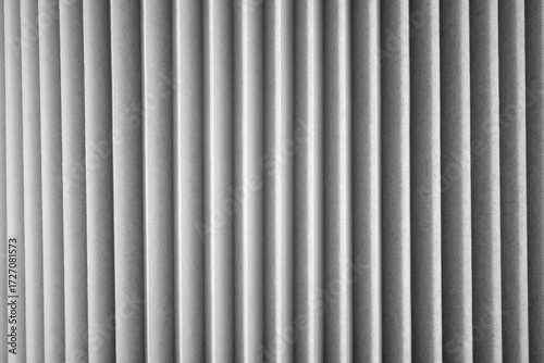 Vertical textures create a striking pattern of light and shadow in a simplistic setting