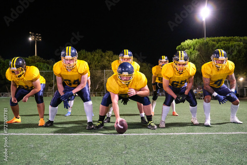 Tablou pe pânză American football players in yellow and blue uniforms getting ready for a night