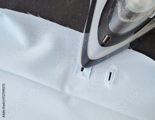 Fotografie Iron glides on crisp fabric, evoking Labor Day's toil and tactile satisfaction,