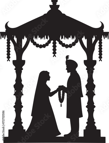 Silhouette of Indian wedding couple exchanging garlands under a mandap