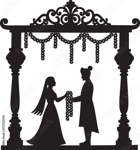 Silhouette of Indian wedding couple exchanging garlands under ornate arch