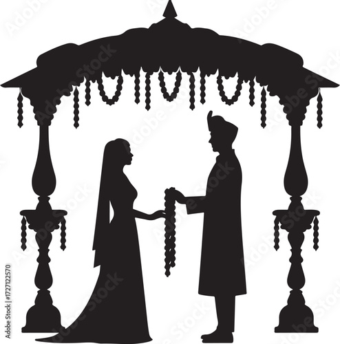 Silhouette of Indian wedding couple exchanging garlands under canopy