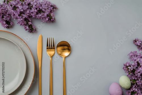 Elegant Table Setting With Golden Cutlery and Fresh Purple Flowers in a Simpl...