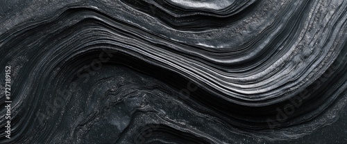 Abstract grayscale image showcasing layered, undulating forms resembling folded fabric or geological strata.  The texture is smooth yet subtly rough, creating a sense of depth and movement