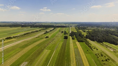 Aerial drone footage of long, colorful striped patterns on a farmland. The vibrant agricultural design creates a striking and picturesque rural landscape.