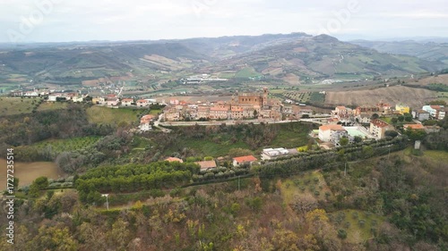 Aerial drone footage circling around the village of Campofilone in Italy. The view captures traditional houses, rolling hills, and the charm of the Italian countryside.