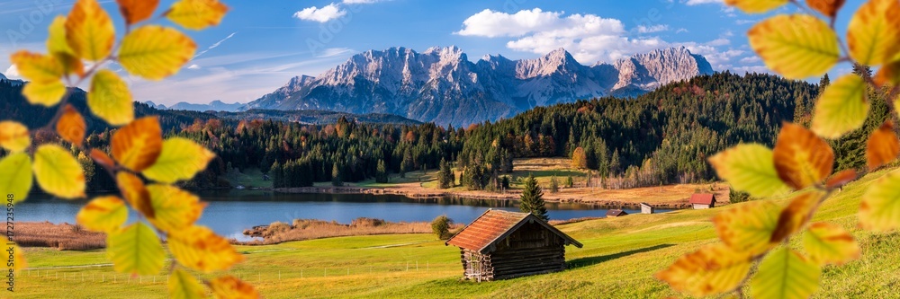 Fototapeta premium Eine farbige Herbstlandschaft an einem See in Bayern vor dem Karwendelgebirge - FOTOMONTAGE - digital bearbeitet