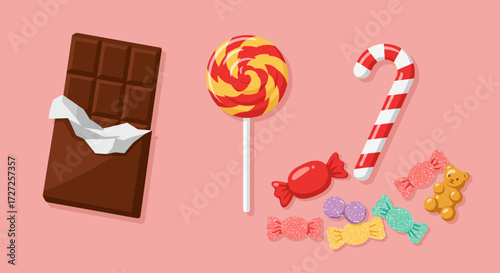 Assortment of chocolate bar lollipop candy cane and various candies on pink
