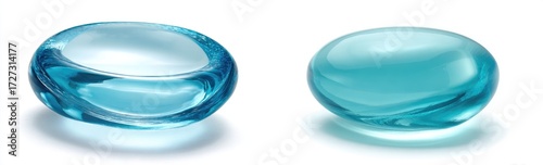 Two smooth, translucent, light-blue glass objects, one shaped like a shallow bowl and the other a rounded pebble, are displayed against a white background, casting subtle shadows