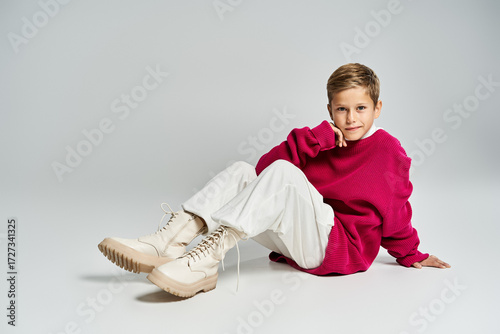 Wallpaper Mural Cute preteen boy poses stylishly in trendy winter outfit against neutral backdrop Torontodigital.ca