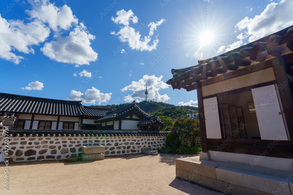 Fototapeta premium Namsangol Hanok Village and Seoul Tower Seoul's landmarks include a well and an ancient pavilion with a clear view of Seoul Tower.