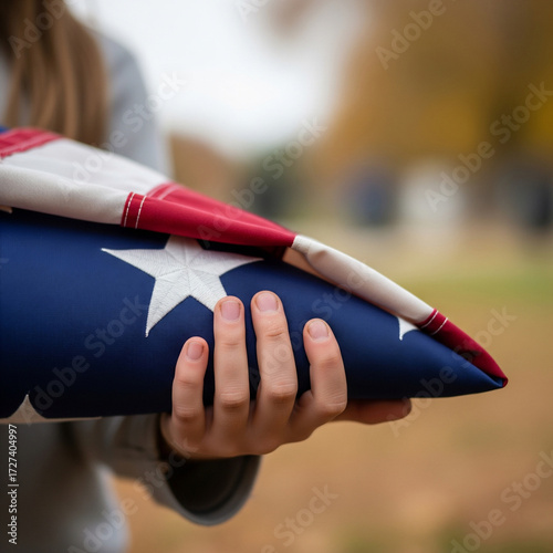Child's Hands Holding a Triangle-Folded American Flag