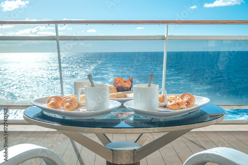 Table basse pour deux personnes avec un petit déjeuner sur la terrasse d'une cabine balcon d'un navire de croisière avec vue sur la mer.	