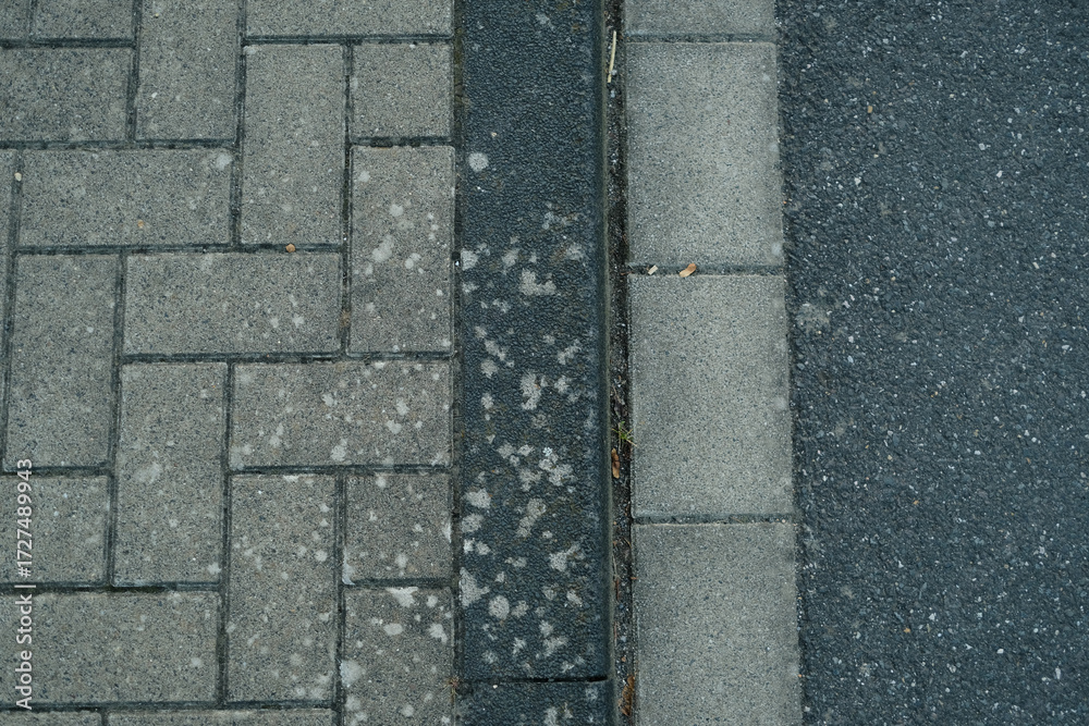 Fototapeta premium A brick sidewalk with a black line separating it from the street