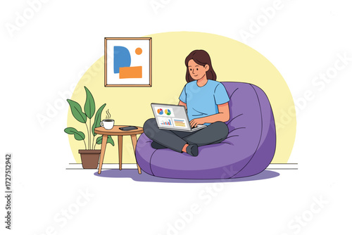 Young woman working from home on a laptop in a comfortable beanbag chair.
