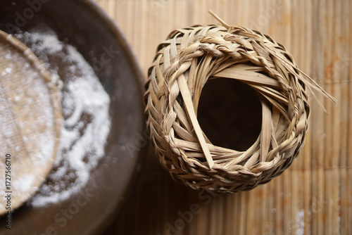 Processo tradicional da farinha de mandioca: tacho de torrar farinha, farinha branca e tipiti de palha usado para prensar a mandioca ralada.