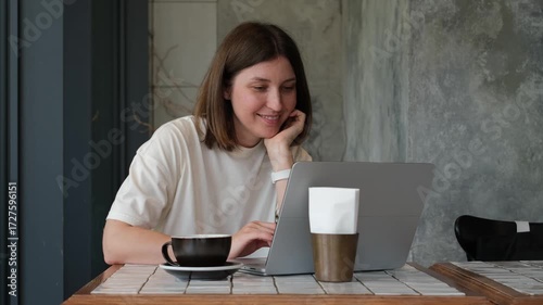 Cheerful Caucasian Woman Working on Laptop in Cafe