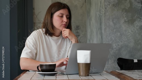 Focused Caucasian Woman Working on Laptop in Cafe