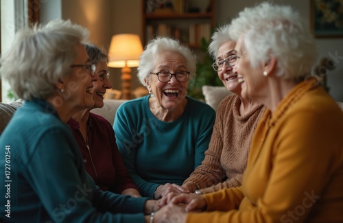 Five happy senior women laugh heartily, talk in cozy home living room. Elderly friends enjoy vibrant social gathering, share life stories, connect deeply, feeling immense joy. Old ladies show strong
