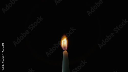 Quadro em tela Tiny candle staying black background in stillness