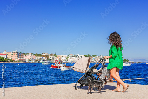 A tender mother enjoys the landscape of Ischia Ponte with her little son