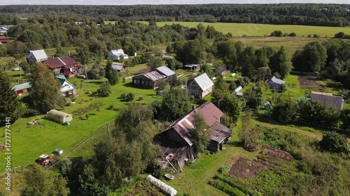 an old, out-of-the-way settlement in a remote area surrounded by forests, wooden houses stand in summer among greenery