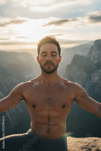 Young man practicing yoga on a mountain peak overlooking Yosemite Valley at sunrise, wide-angle panoramic, cinematic editorial style, dramatic misty mountains.
