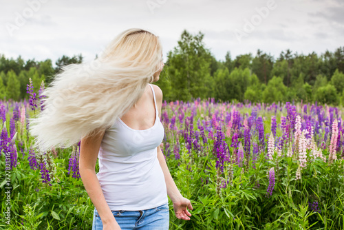 moscow, russia, 13.07.2017 A blonde woman with long hair is walking through a field of purple flowers