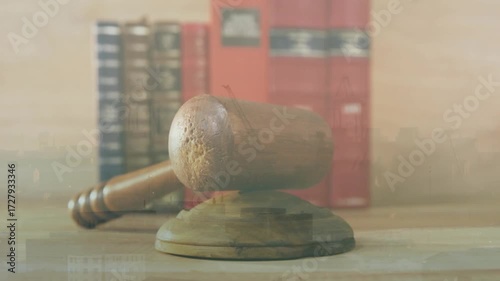 Camera opening on gavel block amid law books, holding steady changing lighting displaying grain