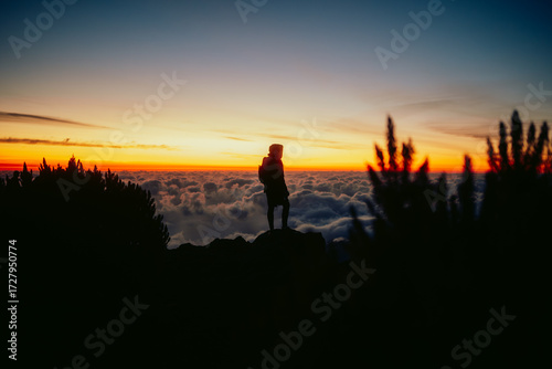 silhouette of a man in a sunset above the clouds