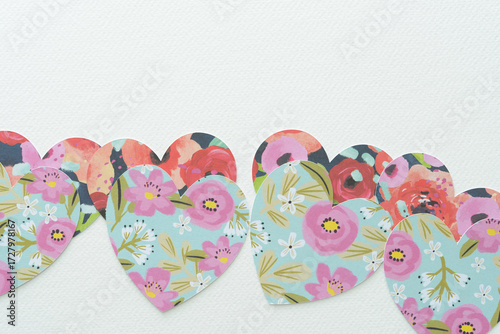 set of layered cut paper hearts featuring floral patterns on blank paper