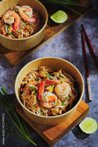 Pad Thai stir-fried with shrimp, eggs, peanuts and lime, served in paper.